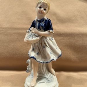 Porcelain figurine lady with berries. 7“ x 3“ blue and white.
